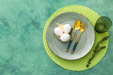 Beautiful table setting for Easter celebration on green backgroundの写真素材