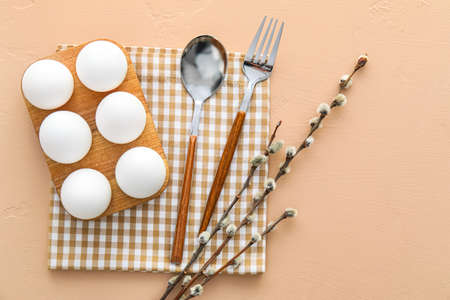 Beautiful table setting for Easter celebration and pussy willow branches on beige backgroundの写真素材