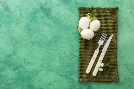 Beautiful table setting for Easter celebration on green background