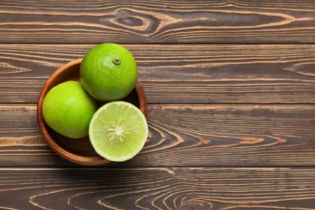Bowl of ripe bergamot fruits on wooden background