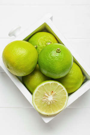 Drawer with ripe bergamot fruits on light wooden background