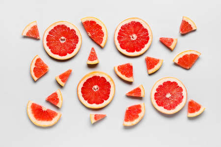 Slices of tasty ripe grapefruit on light backgroundの写真素材