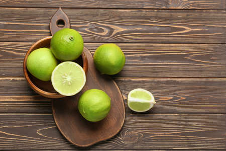 Bowl with ripe bergamot fruits on wooden backgroundの写真素材
