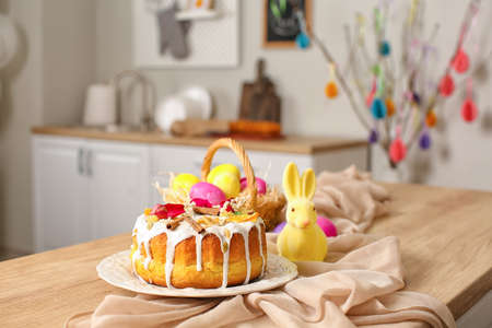 Easter cake, rabbit and basket of painted eggs on kitchen counter, closeupの写真素材