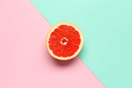 Half of tasty grapefruit on color backgroundの写真素材