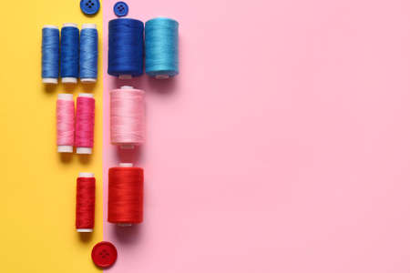 Thread spools and buttons on color backgroundの写真素材