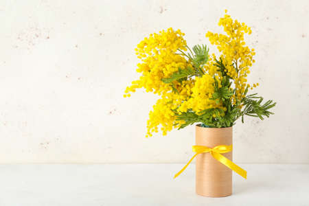 Vase with beautiful mimosa branches on light tableの写真素材