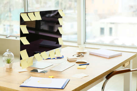 Workplace with many sticky note papers on PC monitor in office