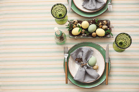 Festive table setting for Easter celebration on light background