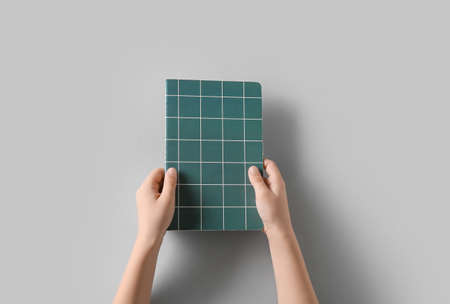 Child's hands with notebook on white backgroundの写真素材