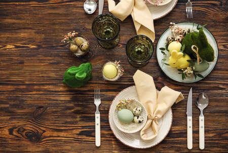Stylish table setting for Easter celebration on wooden background