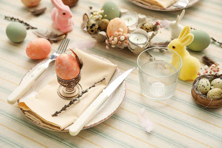 Festive table setting for Easter celebration on light background