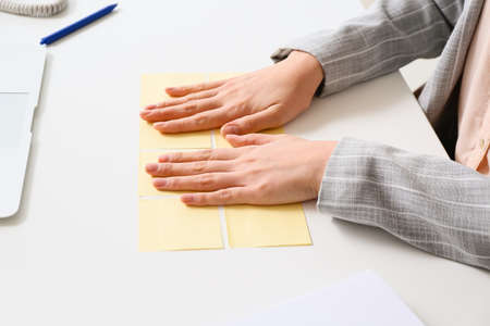 Young manager with sticky note papers at her workplace, closeup
