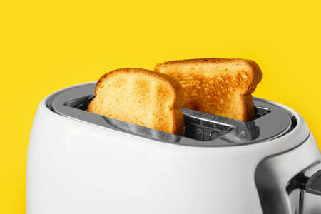 Modern toaster with bread slices on yellow background, closeupの写真素材