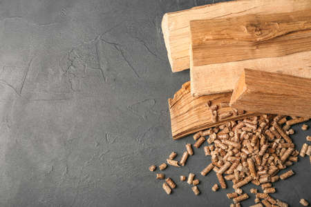 Heap of pellets and firewood on dark backgroundの写真素材