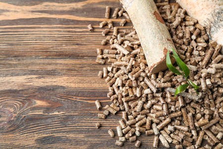 Heap of wood pellets and logs on wooden backgroundの写真素材