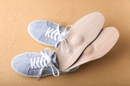 Pair of shoes and orthopedic insoles on color backgroundの写真素材