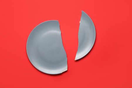 Broken ceramic plate on red backgroundの写真素材