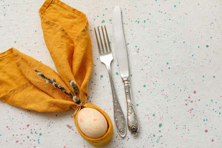 Stylish table setting for Easter celebration with pussy willow branches on light background