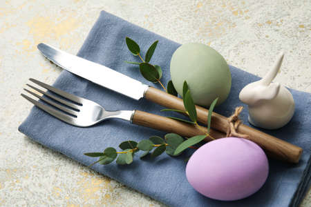 Stylish table setting for Easter celebration on light background, closeup