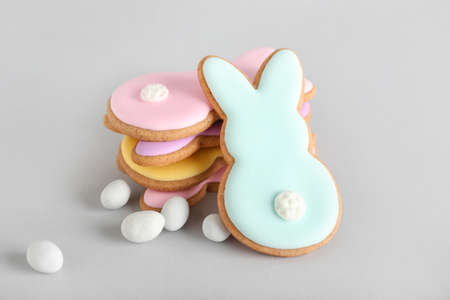Tasty Easter cookies in shape on bunny and candies on light background
