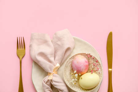 Stylish table setting for Easter celebration on pink background