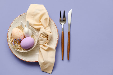 Stylish table setting for Easter celebration on purple backgroundの写真素材