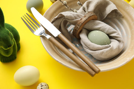 Stylish table setting for Easter celebration on yellow background, closeupの写真素材