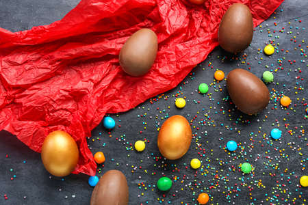 Composition with Easter eggs with candies and sprinkles on dark backgroundの写真素材