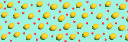 Many ripe lemons and raspberries on turquoise background. pattern for design