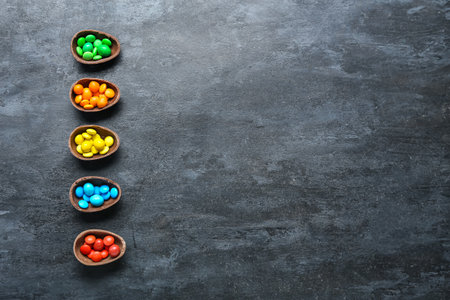 Halves of Easter eggs with different candies on dark backgroundの写真素材