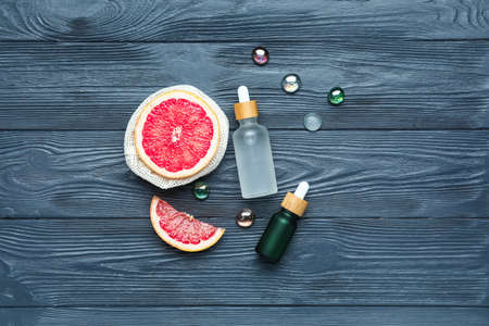 Composition with grapefruit and bottles of essential oil on dark wooden backgroundの写真素材