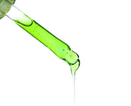 Glass dropper with sample of cosmetic serum isolated on whiteの写真素材