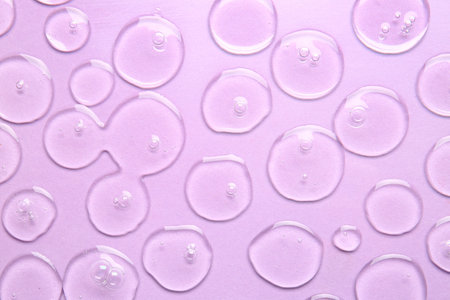 Drops of cosmetic serum on color backgroundの写真素材