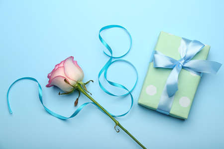 Figure 8 made of ribbon, gift box and flower for International Women's Day celebration on blue backgroundの写真素材