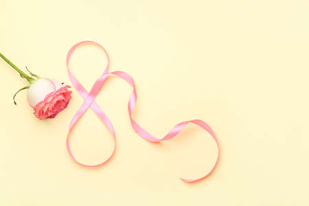 Figure 8 made of ribbon and flower for International Women's Day celebration on beige backgroundの写真素材