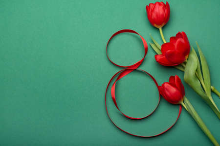 Figure 8 made of ribbon and flowers for International Women's Day celebration on green backgroundの写真素材