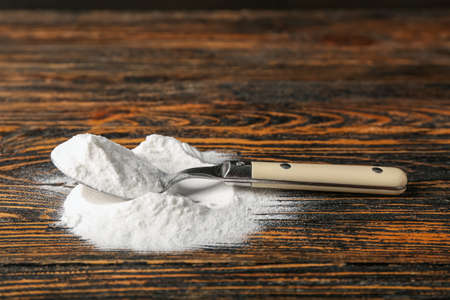 Pile of baking soda and spoon on wooden backgroundの写真素材