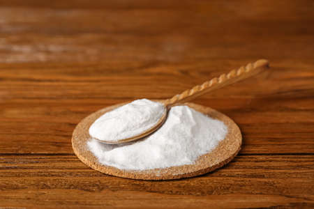 Pile of baking soda and spoon on wooden backgroundの写真素材