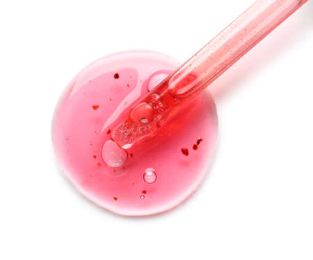 Glass dropper and sample of cosmetic serum on white backgroundの写真素材