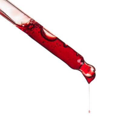 Glass dropper with sample of cosmetic serum isolated on whiteの写真素材