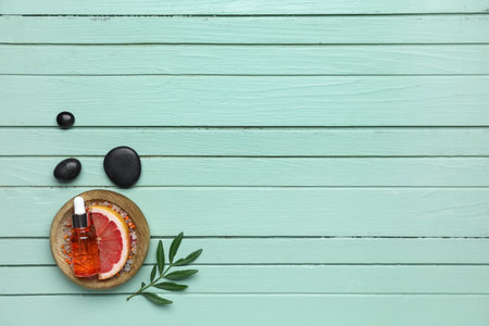 Composition with slice of grapefruit and bottle of essential oil on color wooden backgroundの写真素材