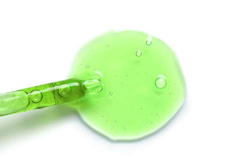 Glass dropper and sample of cosmetic serum on white backgroundの写真素材