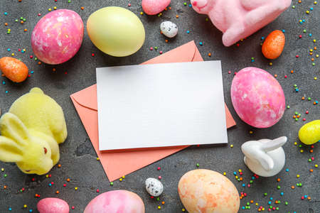 Beautiful Easter composition with blank card, eggs and decor on dark background