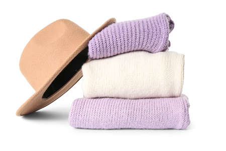 Stack of knitted sweaters and felt hat on white backgroundの写真素材