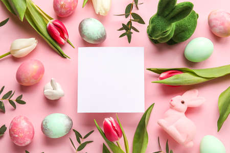 Composition with blank card, flowers and Easter eggs on pink backgroundの写真素材