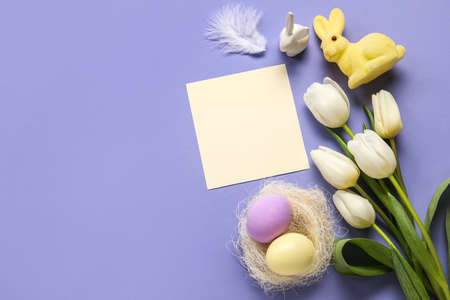 Beautiful Easter composition with blank card, tulip flowers and eggs on lilac background