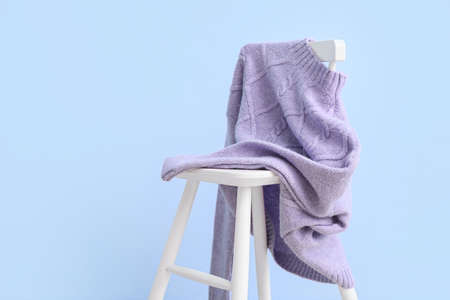 Stylish lilac sweater on chair near color wallの写真素材