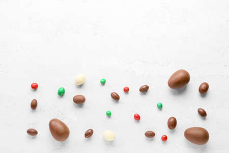 Composition with chocolate Easter eggs and candies on light backgroundの写真素材