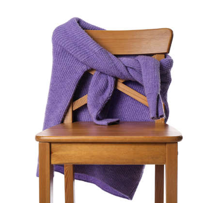 Stylish knitted purple sweater on wooden chair against white backgroundの写真素材